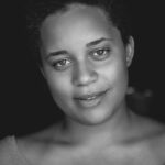 Home Close-up black and white portrait of a smiling woman with natural beauty.